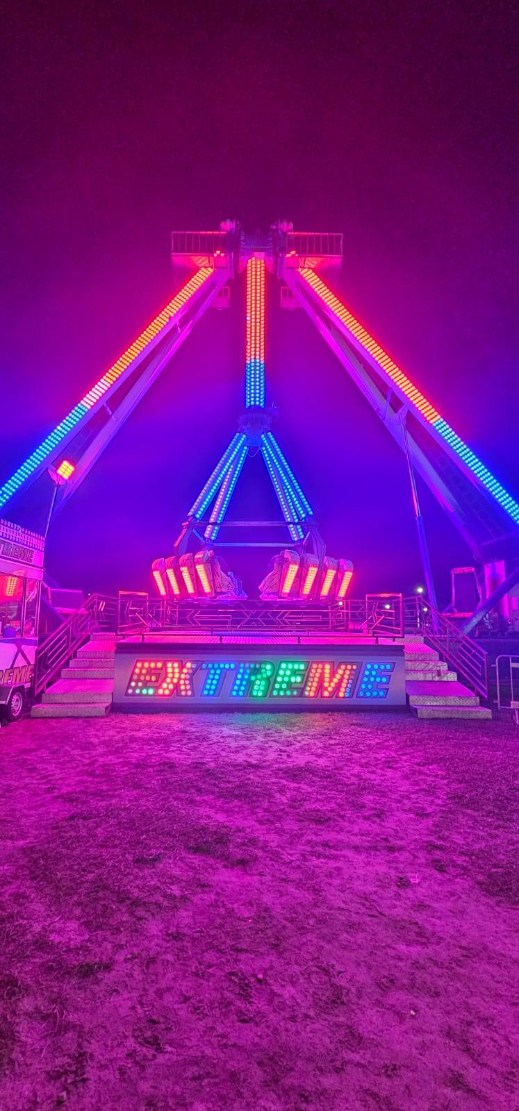 Neonowo oświetlona atrakcja Extreme po zmroku